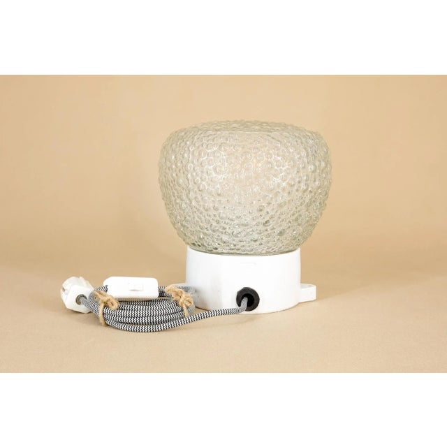 This lamp can be used both as a table lamp and a wall lamp. Its massive ceramic base and the thick bubble glass make it a...