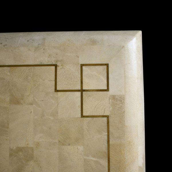 A mid-century modern dining table with a tessellated stone top, offering rich texture and a substantial feel. The...