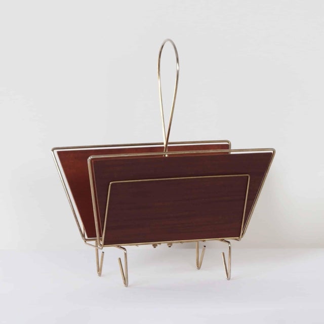Vintage magazine rack from the 1950s, designed in the distinctive rebellious modern style. The combination of bent brass...