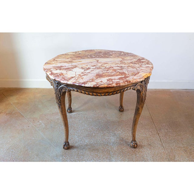 A French carved walnut center table from the 19th century, with variegated marble top, twisted ribbon molding and ball-...