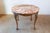A French carved walnut center table from the 19th century, with variegated marble top, twisted ribbon molding and ball-...