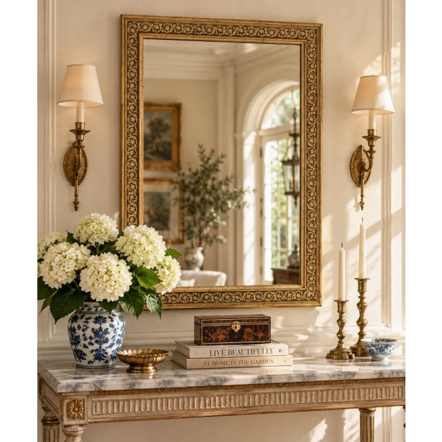 An elegant Neoclassical or Regency style giltwood mirror featuring a richly painted frame with scrolling acanthus details...