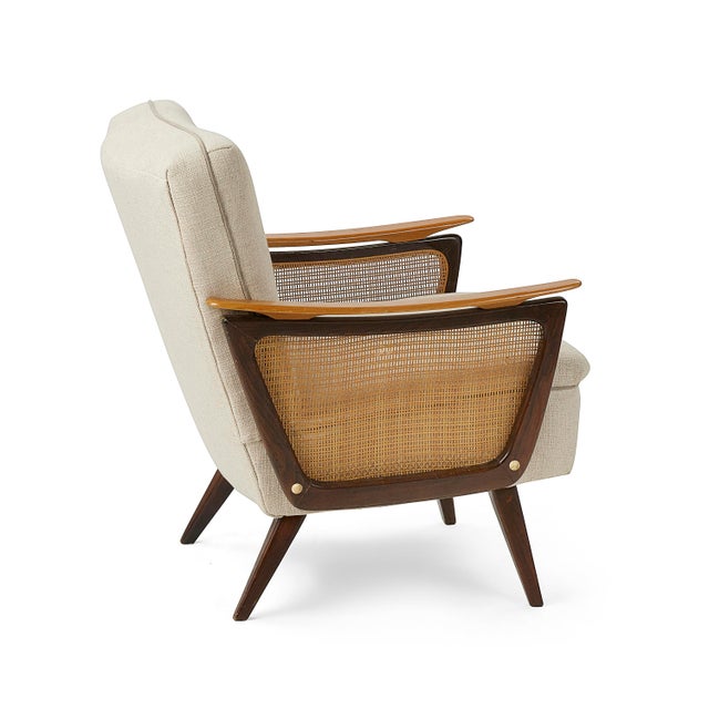 This vintage mid-century chair with cane and wood armrest, dating back to the 1960s, has been recently upholstered with...