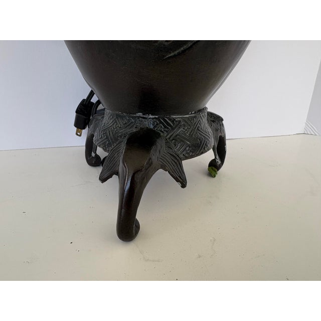 This striking sculptural table lamp features an Asian-inspired metal body finished in a deep bronze-brown tone, richly...