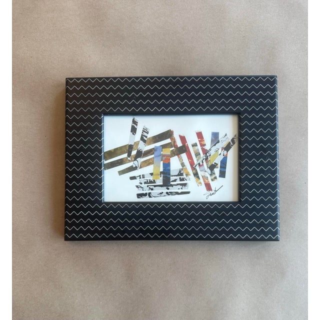 A striking mixed media collage composed of layered paper strips in black, white, gold, and pops of color. The composition...