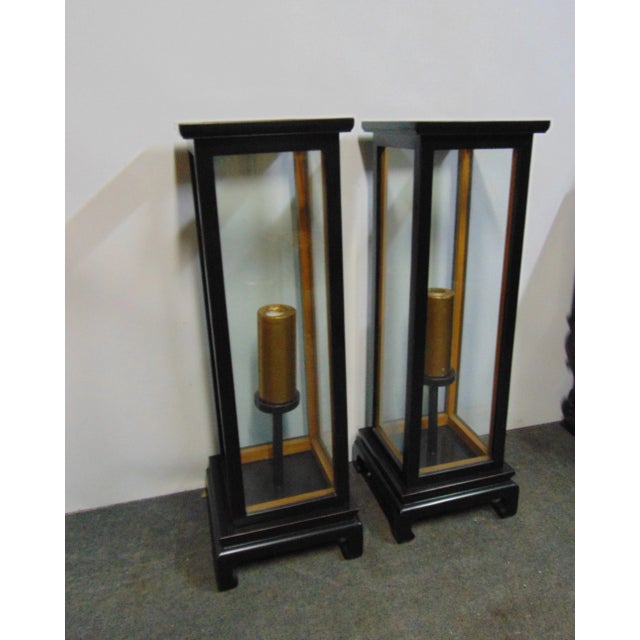A pair of Chinoiserie lantern style candle stands , black lacquered painted finish with gold candles , candles are...