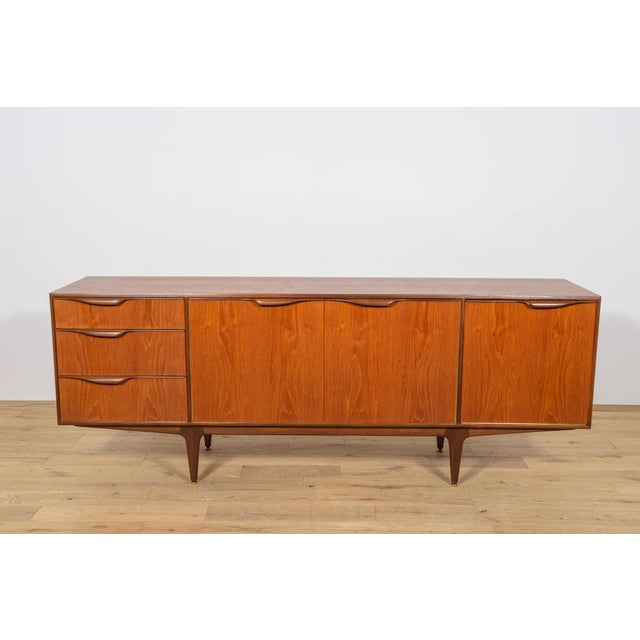 This mid-century sideboard in teak was produced in Great Britain, designed Tom Robertson to Mcintosh in the 1960s. The...