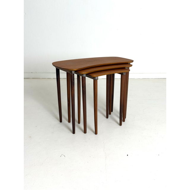 Danish Teak Nesting Tables, 1960s Elegant set of three Danish nesting tables crafted from beautifully aged teak during the...