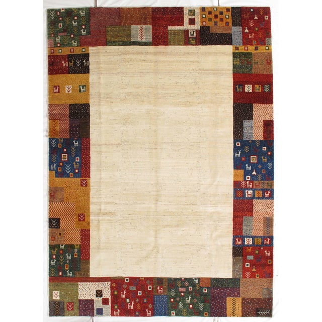 Vintage hand-knotted Persian Fine Lori Gabbeh rug featuring a minimalist field framed by a vibrant patchwork border with...