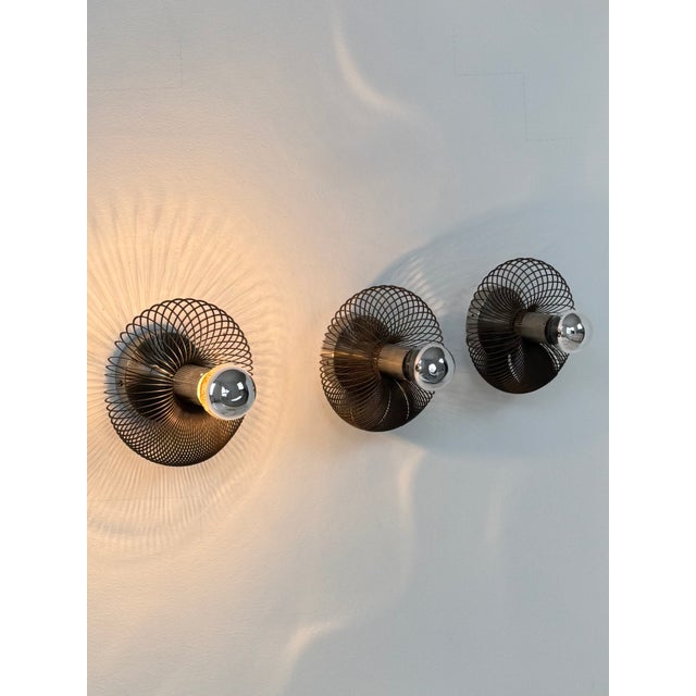 Set of three metal wall lights, made in France in the 1970s. Original design offering interesting plays of light and a...