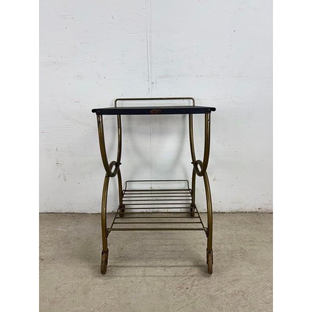This mid century modern bar cart features metal construction, petite design, black painted top, brass accented base with...