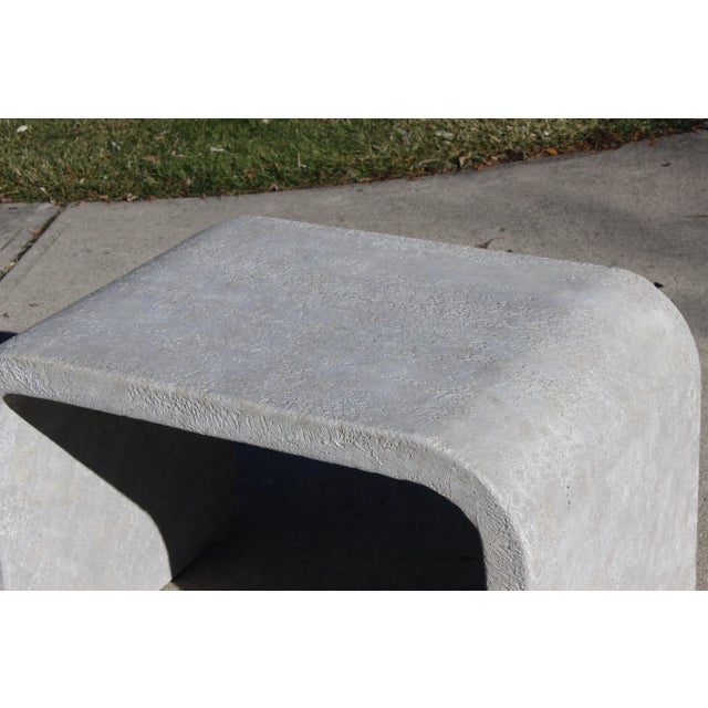 Simple, streamlined waterfall table. I do believe it to be a plaster with a faux stone finish. Weighty and substantial.