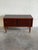 This compact storage piece features a clean rectilinear form and sleek sliding doors that reveal an undivided interior...