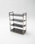 Set of two chrome-plated metal shelving units with dark black tempered glass shelves, inspired by the industrial and...