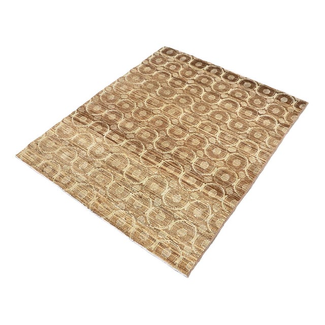 A striking contemporary accent piece, this small area rug features a warm camel brown hand-spun wool base artistically...