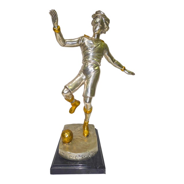 This bronze statue captures the lively motion of a boy kicking a soccer ball, full of energy and detail. Measuring 18...