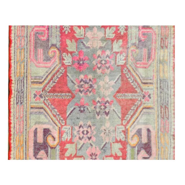 A striking early 20th century Central Asian Khotan rug with wonderful large-scale flowers and scrolling baroque...