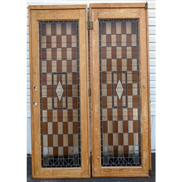 Stunning pair of large stained glass French doors. They show age and wear all around, some damage to wood frame as well to...