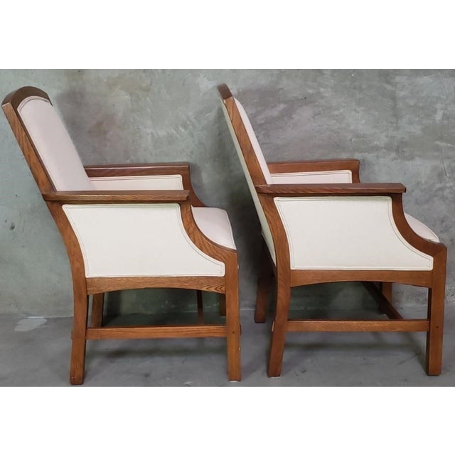 A handsome pair of Stickley armchairs crafted in quarter-sawn oak with clean architectural lines inspired by the American...