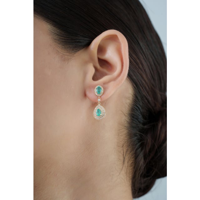 These elegant drop earrings showcase 1.68 carats of natural emeralds, set in 14k yellow gold. The oval-cut emerald...