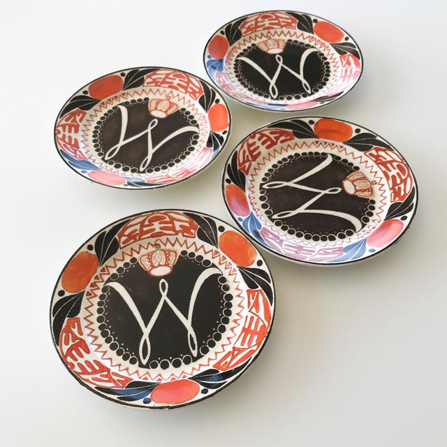 Wonderfully graphic wall plates with stencilled and hand painted design in orange, black and gold commemorating the...