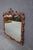 Carved mahogany mirror with ornate scrollwork and pierced crest. Features detailed carving along the frame with a shaped...