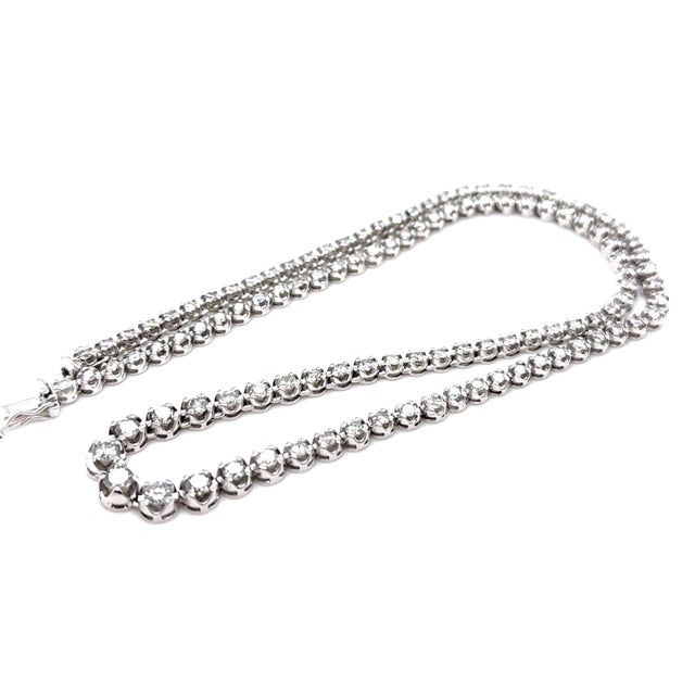 A timeless graduated diamond necklace crafted in platinum, featuring an elegant arrangement of round brilliant cut...