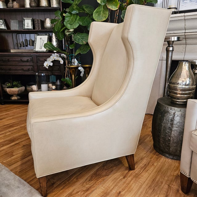 Custom wingback chair in light beige Coraggio Italian leather, made by CBS Furniture in the US- Los Angeles, CA. The back...