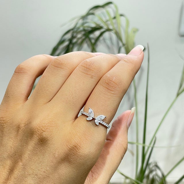 The Four-Stone Marquise-Cut Moissanite Butterfly Cocktail Ring features four marquise-shaped stones arranged in a...
