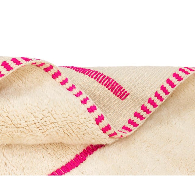 Bold hand-knotted wool rug with an Ivory base and a hand-woven Fuchsia geometric maze pattern, offering a contemporary and...