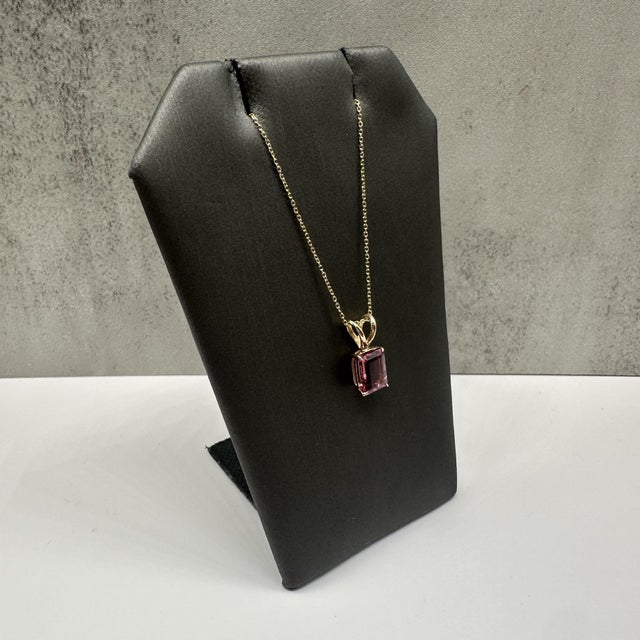This elegant pink tourmaline necklace in 14kt yellow gold features a beautifully cut 1.4 carat emerald cut pink...