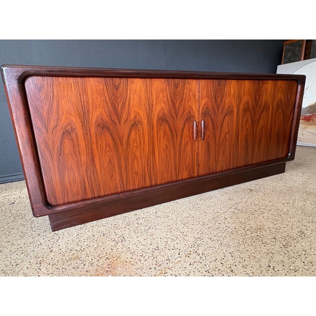 Rare Danish modern rosewood tambour door credenza with center dovetailed drawer section and adjustable shelf on each side.