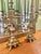 A dramatic pair of Continental Rococo Revival candelabra featuring elaborate scrolling arms, griffin-form handles, and...