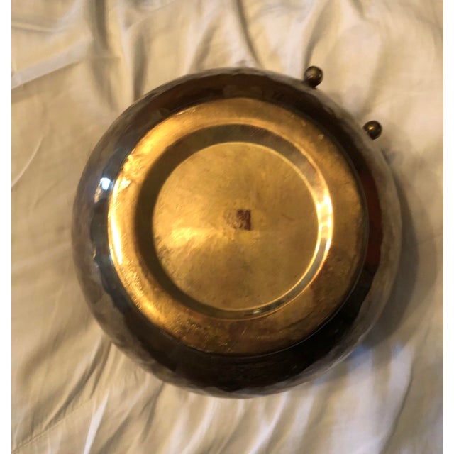 A stunning Hollywood Regency hammered brass planter from India. This round piece features a faux ribbon tied around the...