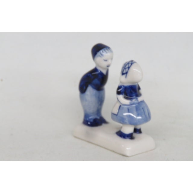This charming Miniature Figurine is made of porcelain. This adorable piece features a young boy and girl in Dutch style...
