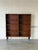 This spacious open storage unit features clean lines and adjustable shelving supported by tapered legs. The rich grain...