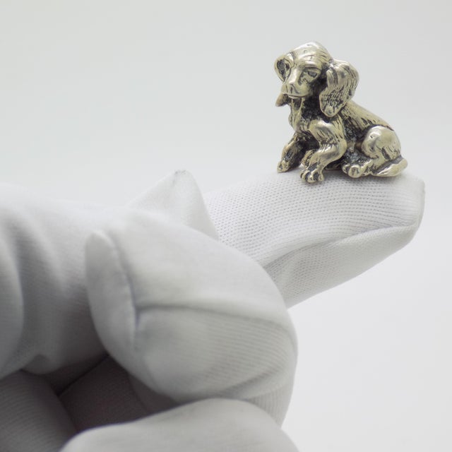 This vintage silver decorative object depicts a sweet puppy dog figurine miniature, crafted as a dollhouse pet accessory,...
