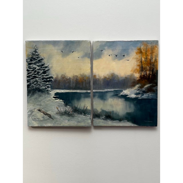 This pair of original signed oil-on-canvas diptych depicting a serene winter white lakeside landscape with snow-covered...