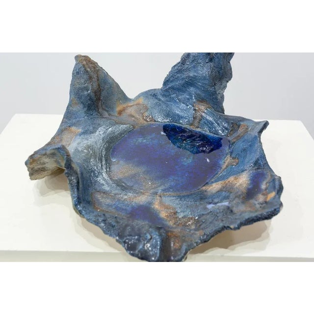 Artistic piece in stoneware painted with metallic oxides and glazed in transparent shine. Corrugated and irregular profile...