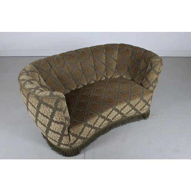 Danish curved Banana form Art Deco couch or sofa made in the 1950s. The legs are made of dark stained wood and the sofa is...