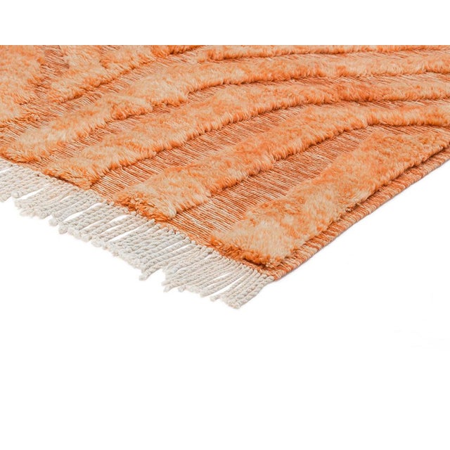 Luxurious hand-knotted rug in vibrant Tiger Orange, featuring a dynamic, textured pattern with natural wool highlights....