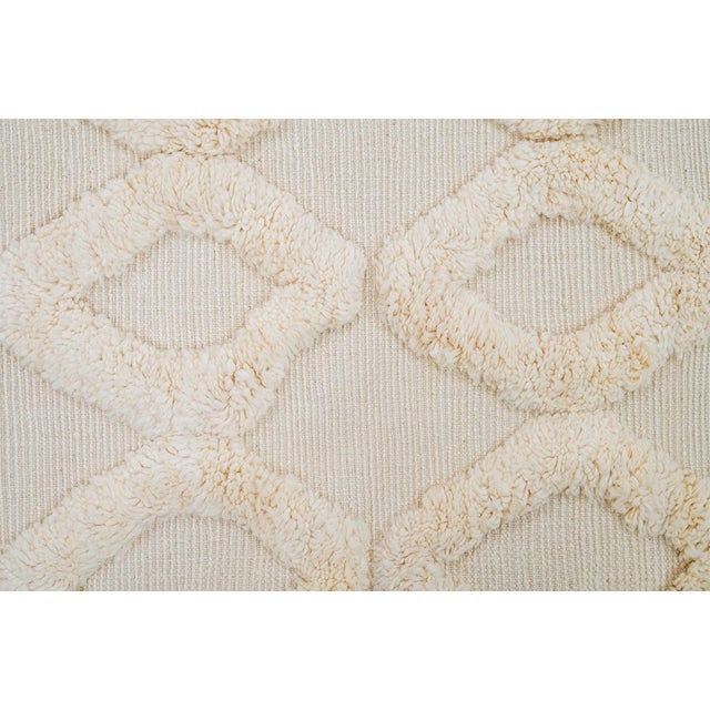 Sophisticated hand-knotted wool rug adorned with a repeating diamond pattern in soft Ivory tones. Its elegant texture and...