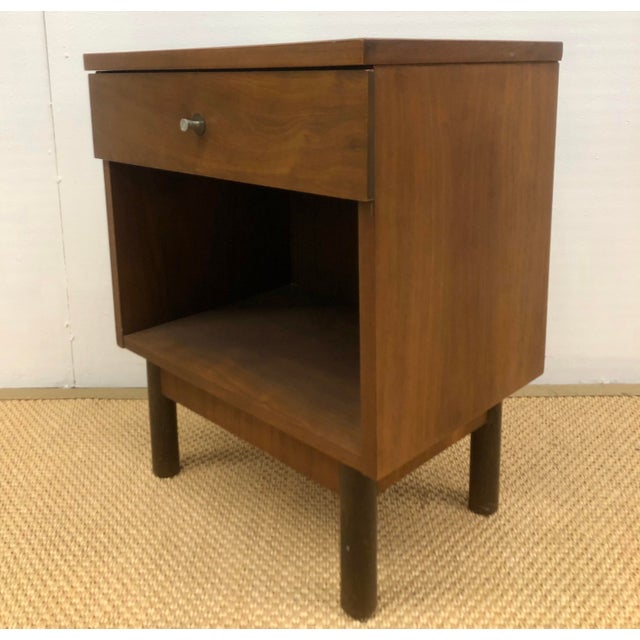 Midcentury Modern walnut Stanley nightstand with a single drawer and original hardware and an open space below for storage...