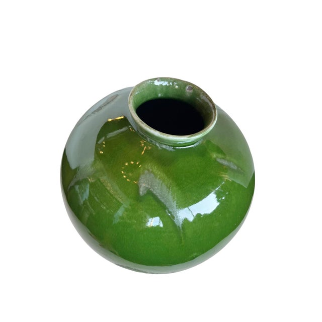 A beautifully simple French ceramic vase distinguished by its rich, vibrant green glaze and classic rounded form. The...