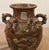 Features a high-fired stoneware body in dark brown and raised dragon motif. The lug handles at the top were used for...