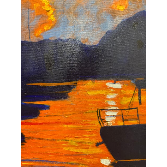 Sunrise heats morning skies and reflects in harbor waters. Sailboats and skiffs are in dark shadow, mere silohuettes...