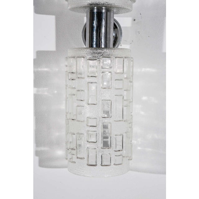 Pair of glass and chrome wall sconces, Each sconce has an up light and a down light. Four pairs available.