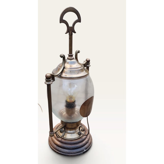 An unusual and highly decorative French vintage hurricane table lamp dating from the 1960s, combining warm patinated...