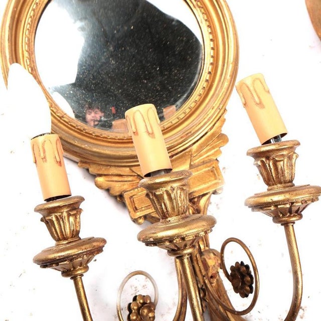 A very decorative pair of Giltwood Wall Sconces (Girandoles) in the Neoclassical Empire Style. Each features a mirrored...