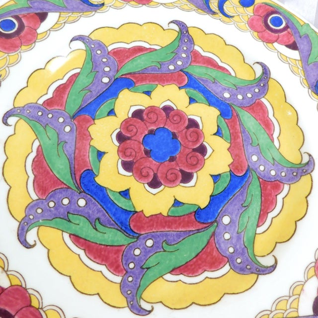 This is a Royal Doulton plate that is a thicker ceramic plate in a very colorful design. I have not been able to identify...